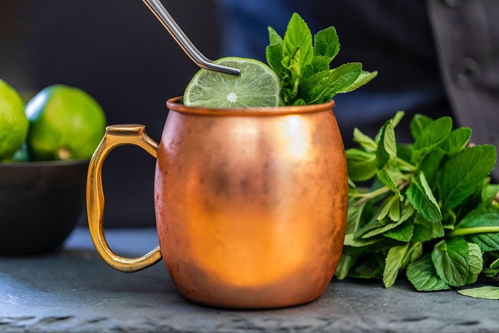 Moscow Mule na caneca de cobre, com rodela de limão e ramo de hortelã