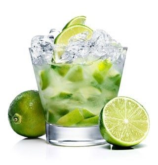Caipiroska de limão num copo baixo com gelo, entre metades de limão